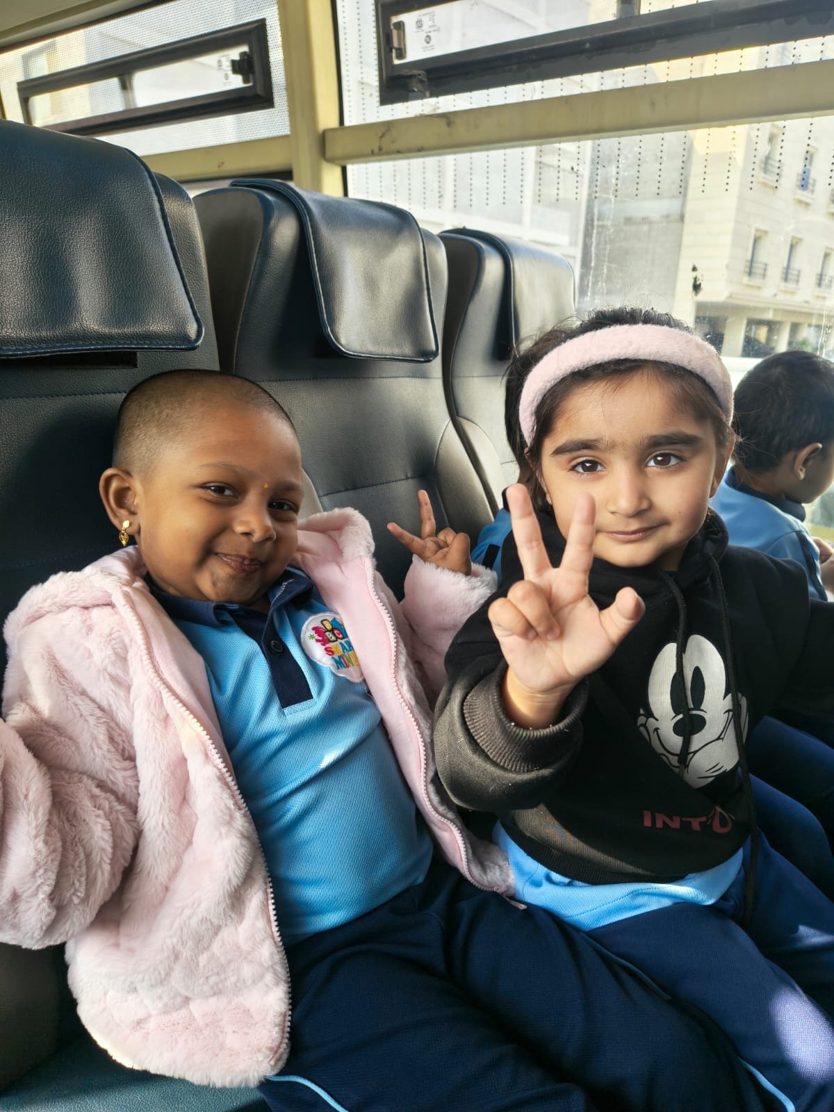 Two happy Smart Minds students riding the school bus